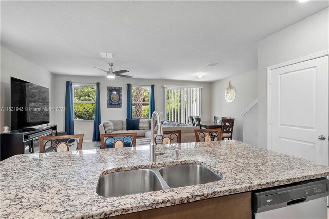 5720 Mentmore Dr, Mangonia Park, FL 33407 - kitchen with stainless steel dishwasher, open floor plan, light stone counters, and a ceiling fan