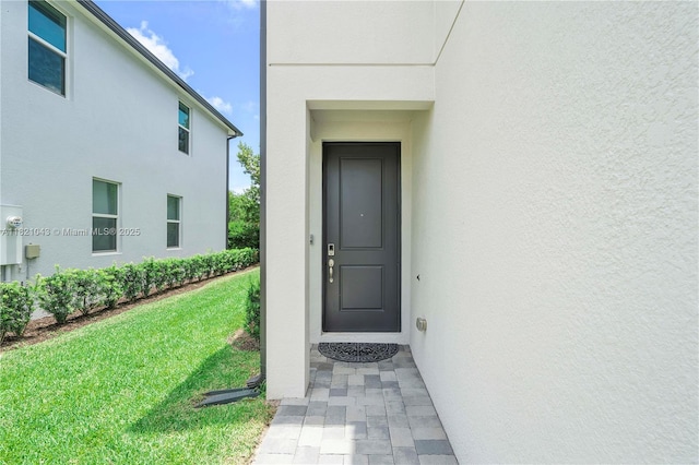 5720 Mentmore Dr, Mangonia Park, FL 33407 - property entrance featuring stucco siding and a lawn