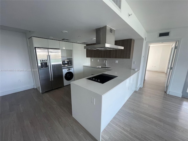 1025 92nd St Unit 607, Bay Harbor Islands, FL 33154 - kitchen with appliances with stainless steel finishes, washer / clothes dryer, island range hood, modern cabinets, and light countertops