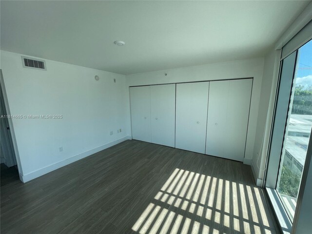 1025 92nd St Unit 607, Bay Harbor Islands, FL 33154 - unfurnished bedroom with dark wood-style flooring and a closet