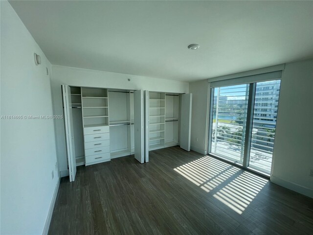 1025 92nd St Unit 607, Bay Harbor Islands, FL 33154 - unfurnished bedroom featuring dark wood-style floors and two closets