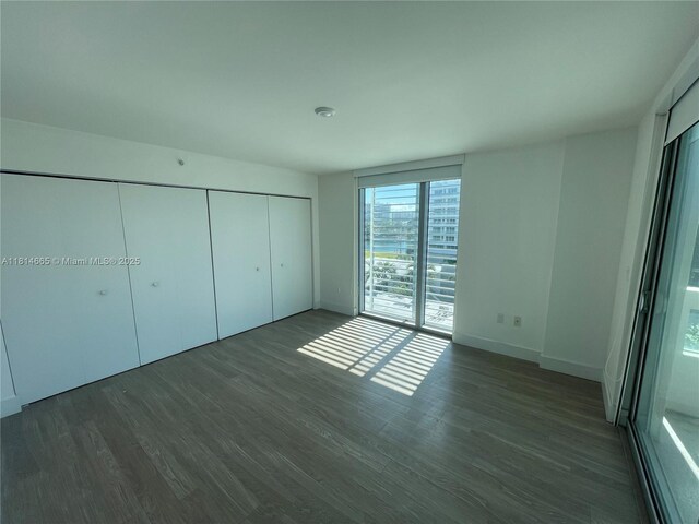1025 92nd St Unit 607, Bay Harbor Islands, FL 33154 - unfurnished bedroom with wood finished floors, access to outside, and a closet
