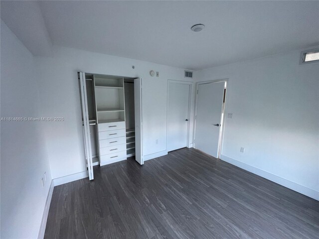 1025 92nd St Unit 607, Bay Harbor Islands, FL 33154 - unfurnished bedroom with dark wood-style flooring and a closet