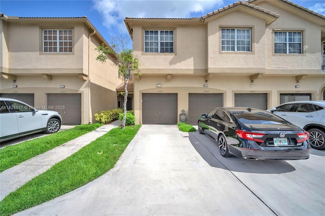 13227 SW 42nd St Unit 8103, Miramar, FL 33027 - view of property featuring an attached garage, stucco siding, and driveway