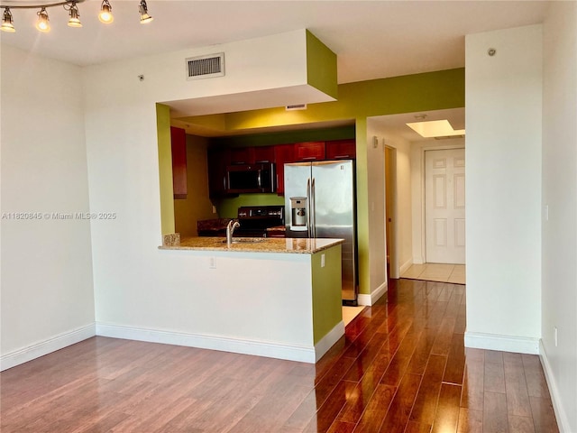 7275 SW 90th Way Unit 405, Miami, FL 33156 - kitchen featuring stainless steel appliances, dark wood-style floors, reddish brown cabinets, a peninsula, and light stone countertops