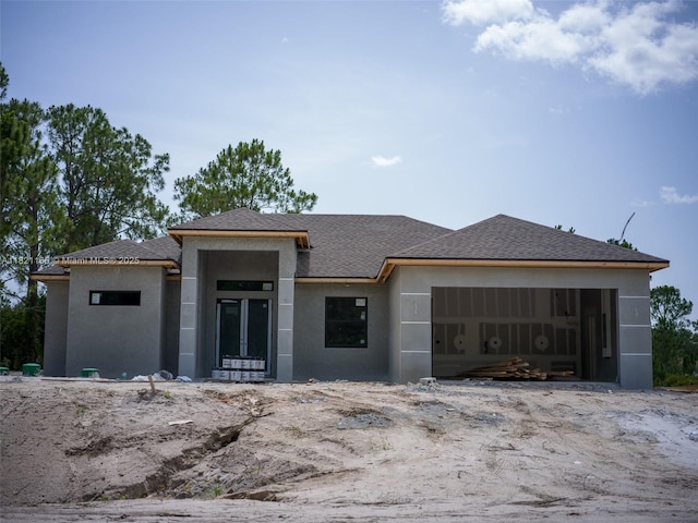 811 Rush Ave, Lehigh Acres, FL 33972 - prairie-style home featuring an attached garage, stucco siding, and roof with shingles