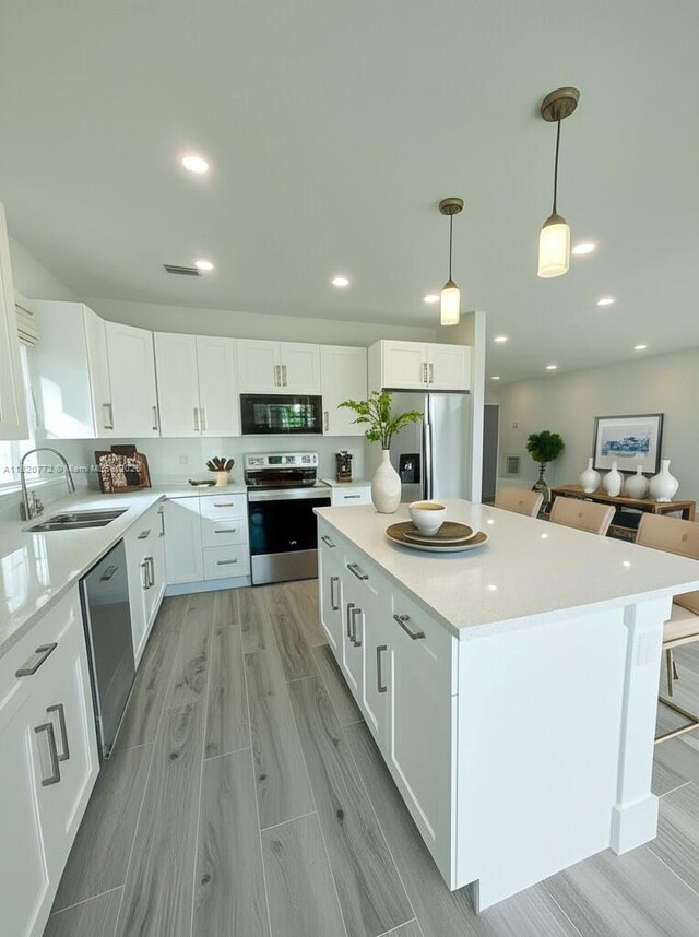 21475 Argosy Ave, Port Charlotte, FL 33954 - kitchen featuring appliances with stainless steel finishes, white cabinets, light countertops, a kitchen island, and recessed lighting