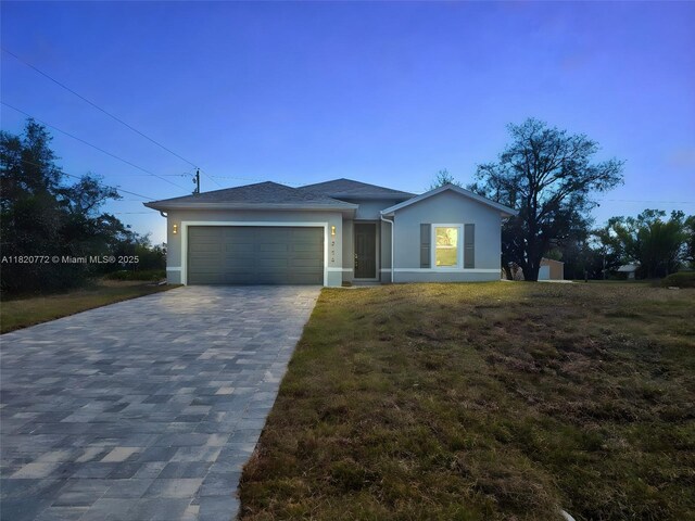 21475 Argosy Ave, Port Charlotte, FL 33954 - view of front facade with stucco siding, a garage, decorative driveway, and a front lawn
