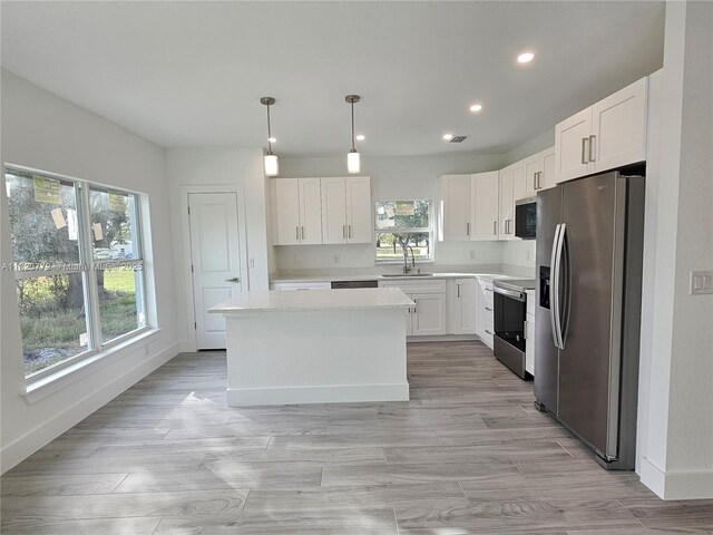 21475 Argosy Ave, Port Charlotte, FL 33954 - kitchen with appliances with stainless steel finishes, light countertops, recessed lighting, white cabinets, and pendant lighting
