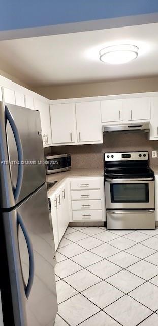 3800 S Ocean Dr Unit 425, Hollywood, FL 33019 - kitchen with stainless steel appliances, under cabinet range hood, white cabinets, and light countertops