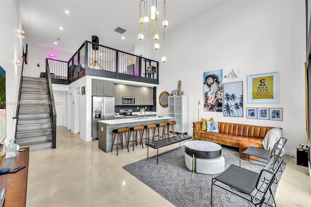 410 NE 36th St Unit 10, Oakland Park, FL 33334 - living room with concrete floors, a towering ceiling, stairs, and recessed lighting