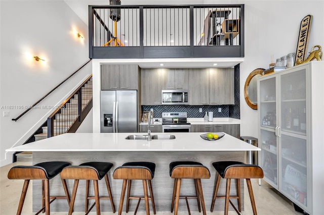 410 NE 36th St Unit 10, Oakland Park, FL 33334 - kitchen featuring stainless steel appliances, a breakfast bar area, gray cabinets, a towering ceiling, and modern cabinets
