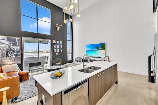 410 NE 36th St Unit 10, Oakland Park, FL 33334 - kitchen featuring stainless steel dishwasher, a center island with sink, light countertops, a high ceiling, and hanging light fixtures