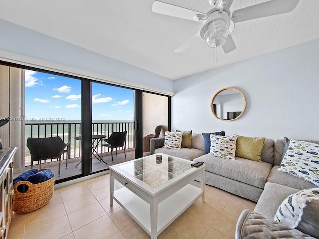 10152 S Ocean Dr Unit 618, Jensen Beach, FL 34957 - living area featuring a water view, light tile patterned flooring, a ceiling fan, and plenty of natural light