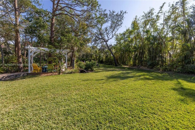 8755 Commodore Dr, Seminole, FL 33776 - view of green lawn with a pergola