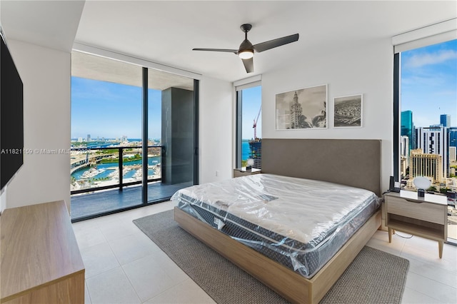 159 NE 6th St Unit 3016, Miami, FL 33132 - bedroom with floor to ceiling windows, access to exterior, a view of city, a water view, and light tile patterned floors