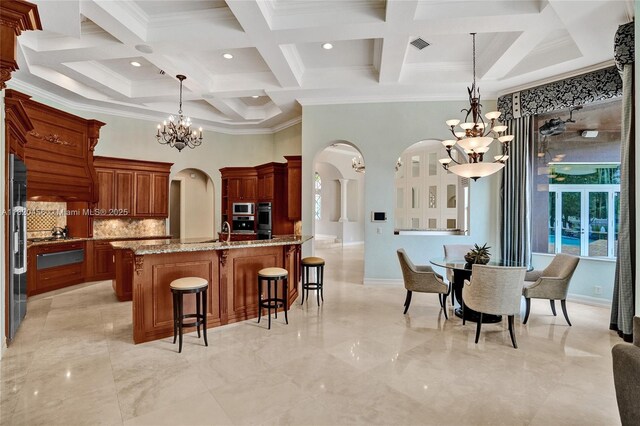 15093 SW 16th St, Davie, FL 33326 - kitchen featuring a chandelier, arched walkways, a towering ceiling, coffered ceiling, and a breakfast bar area