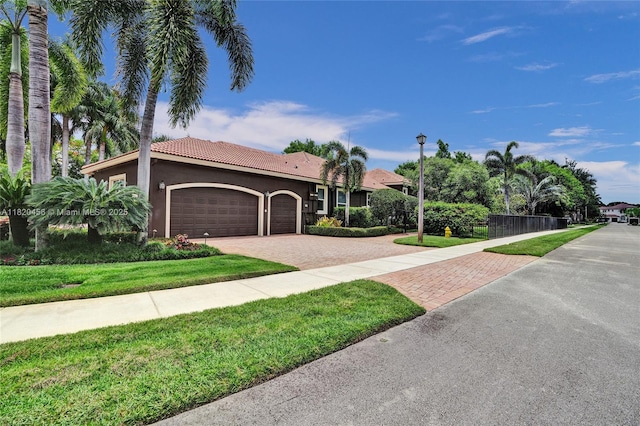 15093 SW 16th St, Davie, FL 33326 - view of front of property featuring decorative driveway, an attached garage, a front yard, stucco siding, and a tile roof