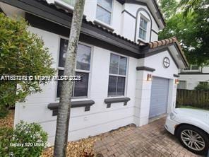 7633 NW 114th Path Unit 7633, Doral, FL 33178 - view of side of home featuring stucco siding, decorative driveway, and an attached garage