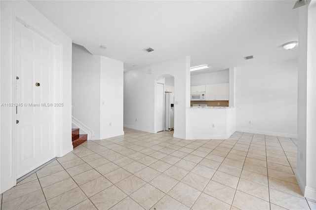 7633 NW 114th Path Unit 7633, Doral, FL 33178 - empty room with light tile patterned flooring, arched walkways, and stairs