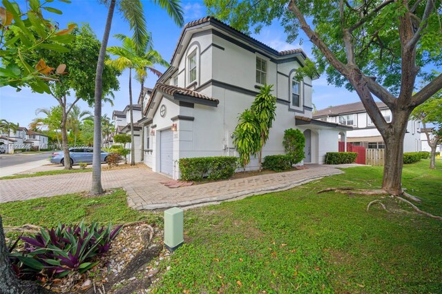 7633 NW 114th Path Unit 7633, Doral, FL 33178 - view of front of house with a tile roof, stucco siding, a garage, a front lawn, and driveway