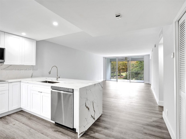 605 Oaks Dr Unit 309, Pompano Beach, FL 33069 - kitchen with appliances with stainless steel finishes, a peninsula, white cabinets, light stone countertops, and open floor plan