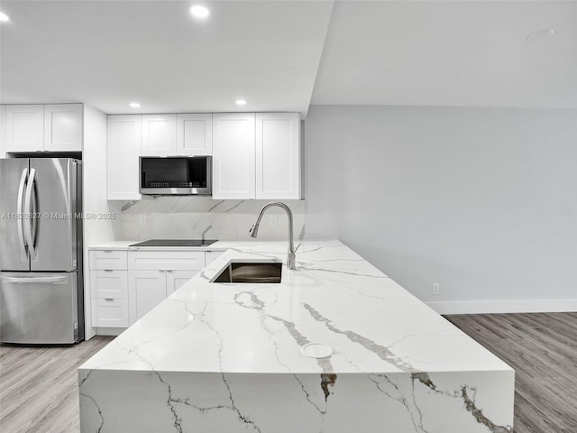 605 Oaks Dr Unit 309, Pompano Beach, FL 33069 - kitchen featuring appliances with stainless steel finishes, light stone counters, white cabinets, light wood-style flooring, and recessed lighting