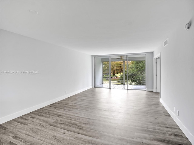 605 Oaks Dr Unit 309, Pompano Beach, FL 33069 - spare room with a smoke detector, wood finished floors, and expansive windows