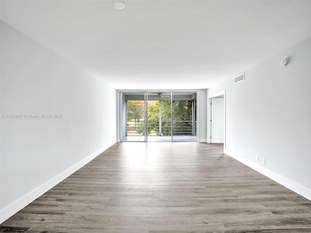 605 Oaks Dr Unit 309, Pompano Beach, FL 33069 - empty room featuring expansive windows, a smoke detector, and wood finished floors