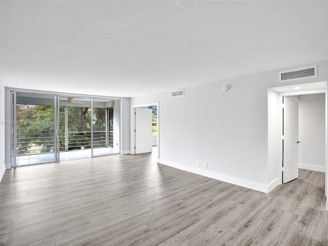 605 Oaks Dr Unit 309, Pompano Beach, FL 33069 - unfurnished room featuring healthy amount of natural light, light wood-type flooring, a ceiling fan, expansive windows, and a smoke detector