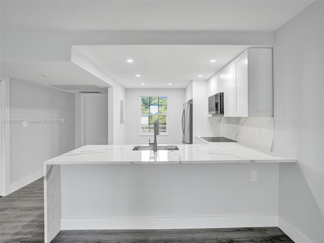 605 Oaks Dr Unit 309, Pompano Beach, FL 33069 - kitchen featuring appliances with stainless steel finishes, a peninsula, light stone counters, white cabinetry, and recessed lighting