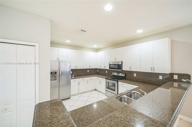 16313 SW 66th St, Miami, FL 33193 - kitchen with stainless steel appliances, decorative backsplash, white cabinetry, light tile patterned floors, and recessed lighting