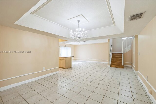 18043 SW 149th Pl, Miami, FL 33187 - empty room featuring a raised ceiling, a chandelier, light tile patterned floors, and stairway