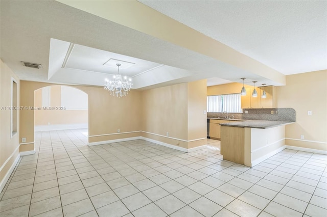 18043 SW 149th Pl, Miami, FL 33187 - kitchen featuring open floor plan, a chandelier, a tray ceiling, a peninsula, and light tile patterned floors