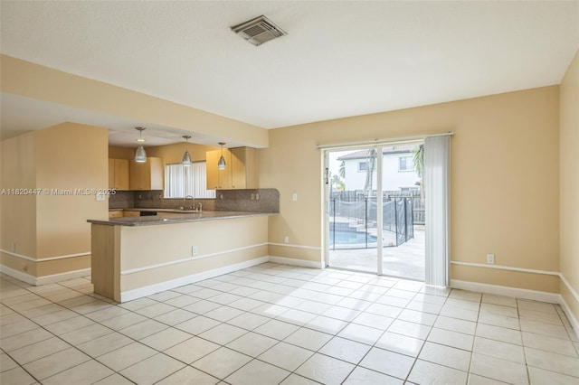 18043 SW 149th Pl, Miami, FL 33187 - kitchen with light tile patterned floors, tasteful backsplash, a peninsula, light brown cabinets, and pendant lighting