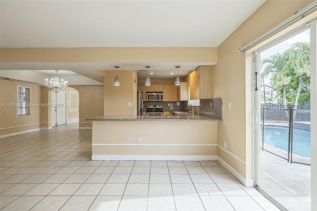 18043 SW 149th Pl, Miami, FL 33187 - kitchen with stainless steel appliances, healthy amount of natural light, a chandelier, and a peninsula