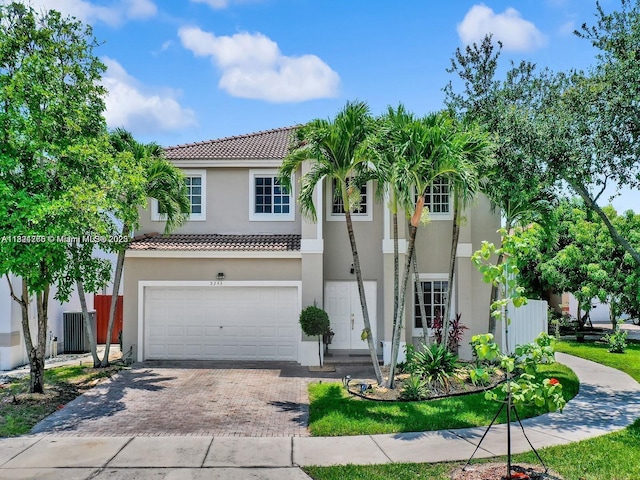 5343 NW 111th Ct, Doral, FL 33178 - view of front facade with a tiled roof, stucco siding, an attached garage, and decorative driveway