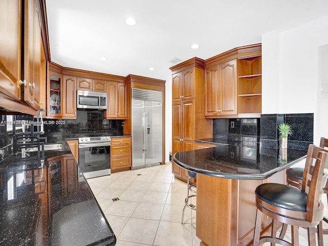 5343 NW 111th Ct, Doral, FL 33178 - kitchen featuring appliances with stainless steel finishes, a peninsula, backsplash, open shelves, and a kitchen breakfast bar