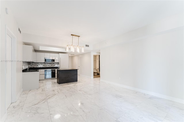 1010 Brickell Ave Unit 1409, Miami, FL 33131 - kitchen featuring stainless steel microwave, a kitchen island, wall oven, backsplash, and light marble finish floors
