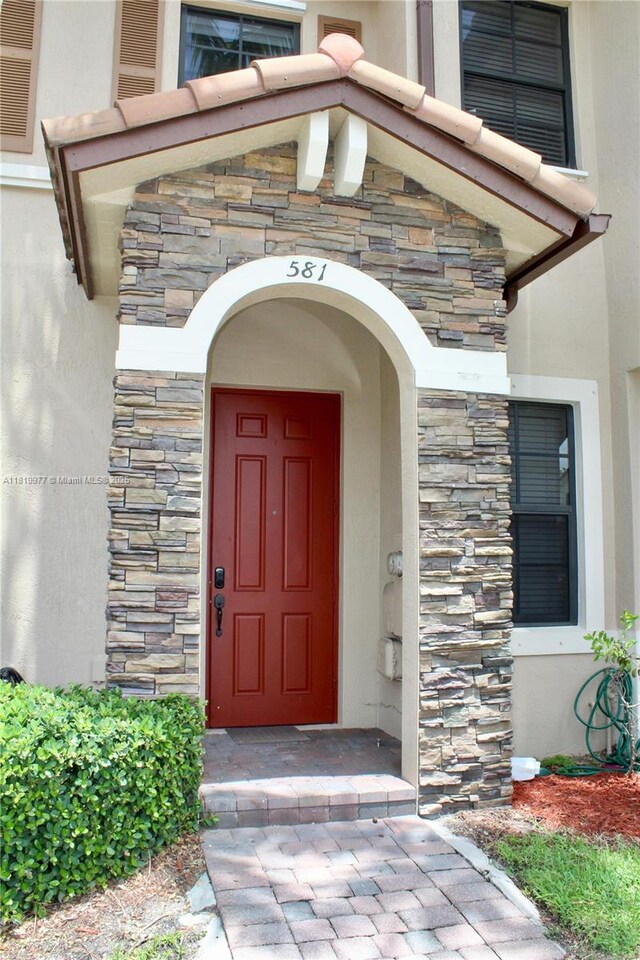 581 SE 32nd Ter, Homestead, FL 33033 - doorway to property featuring stone siding and stucco siding