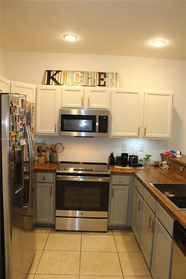 581 SE 32nd Ter, Homestead, FL 33033 - kitchen with stainless steel appliances, wood counters, light tile patterned flooring, gray cabinets, and recessed lighting