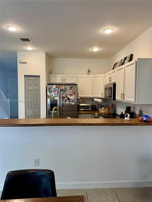 581 SE 32nd Ter, Homestead, FL 33033 - kitchen featuring appliances with stainless steel finishes, a peninsula, tile patterned floors, white cabinets, and recessed lighting