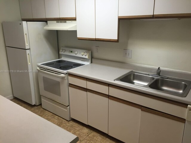 4055 W Mcnab Rd Unit H112, Pompano Beach, FL 33069 - kitchen featuring white appliances, under cabinet range hood, light countertops, light tile patterned flooring, and white cabinetry
