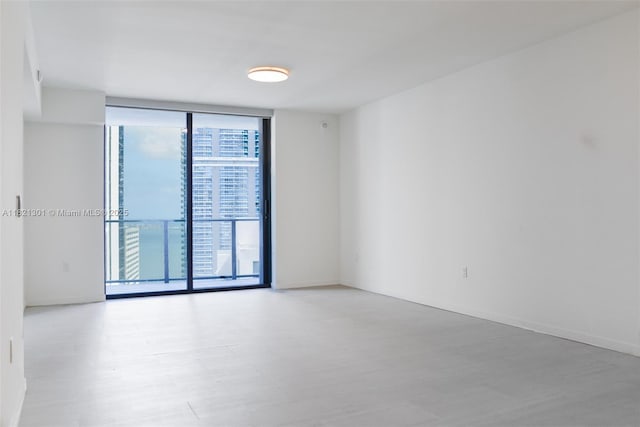 1000 Brickell Plz Unit 3703, Miami, FL 33131 - spare room featuring a wall of windows and wood finished floors
