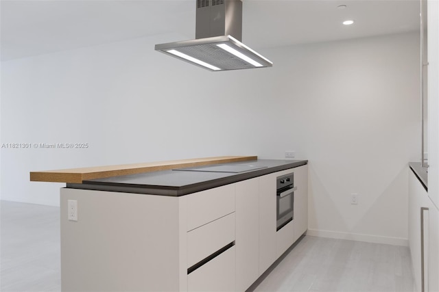 1000 Brickell Plz Unit 3703, Miami, FL 33131 - kitchen featuring island exhaust hood, electric cooktop, dark countertops, oven, and modern cabinets