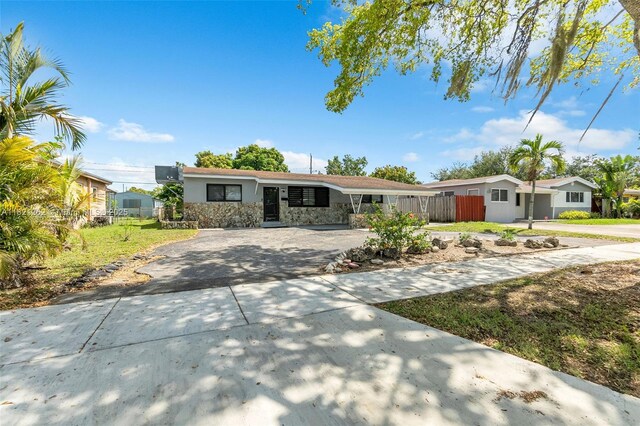7631 Miramar Pkwy, Miramar, FL 33023 - ranch-style house featuring concrete driveway, stucco siding, and stone siding