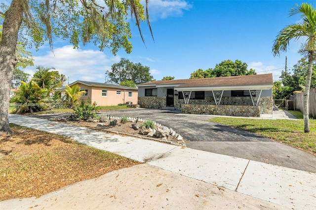7631 Miramar Pkwy, Miramar, FL 33023 - ranch-style house featuring asphalt driveway and stone siding