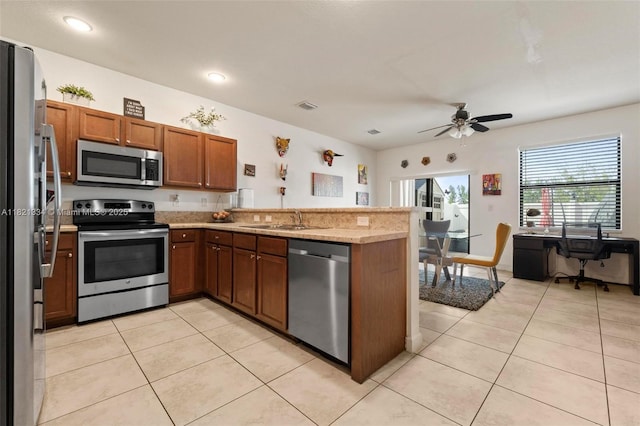 3507 W 89th Pl, Hialeah, FL 33018 - kitchen featuring stainless steel appliances, a peninsula, brown cabinets, a ceiling fan, and light tile patterned floors