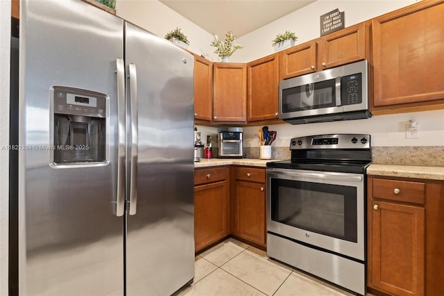 3507 W 89th Pl, Hialeah, FL 33018 - kitchen with stainless steel appliances, light tile patterned floors, and brown cabinetry