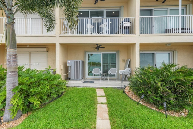 4034 N Ocean Dr, Hollywood, FL 33019 - rear view of property featuring stucco siding, a balcony, a ceiling fan, and a lawn